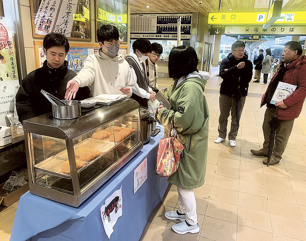 地元名産の商品を販売する日本大国際関係学部の学生（左）＝伊豆箱根鉄道修善寺駅