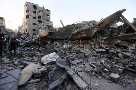２月２８日、パレスチナ自治区ガザ中部で破壊された建物を捜索する住民（ゲッティ＝共同）