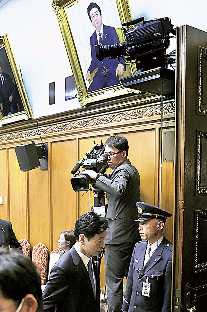 衆院政治倫理審査会を終え、退室する西村前経産相（左）。上は安倍元首相の肖像画＝１日午前（代表撮影）