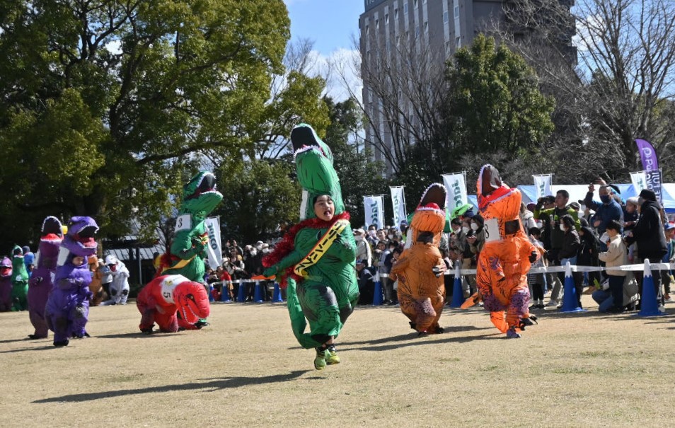 恐竜の格好で全力疾走する参加者＝富士市の中央公園