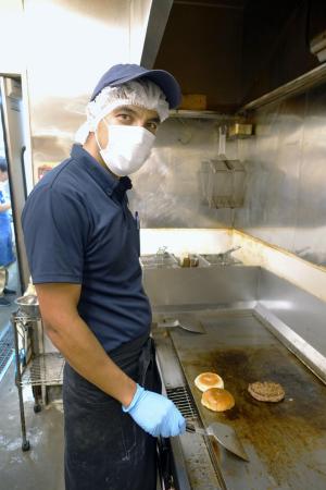 ２０２３年８月２５日撮影　黒毛和牛のハンバーガーを作るヌーリ・ジャムシドさん。妻も同じ職場で働く＝宮崎県西都市の有田牧畜産業