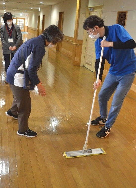支援員の助言を受け清掃業務を体験する中村昇聖さん（右）＝２月下旬、島田市内
