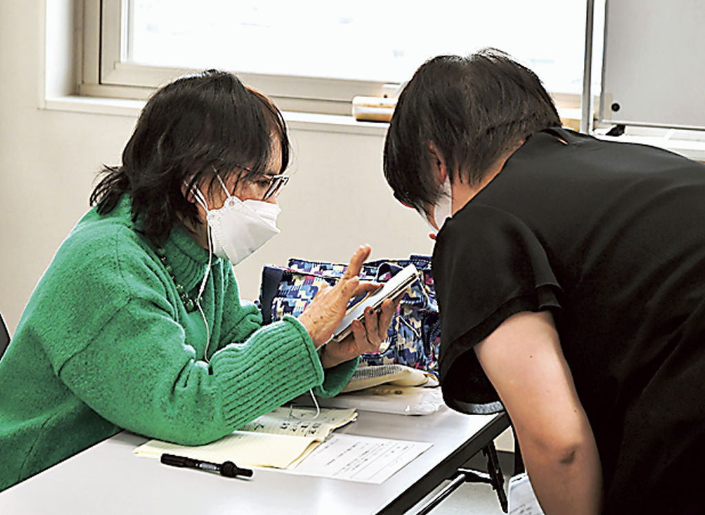 スマホの基本操作を教わる参加者（左）＝富士宮市役所