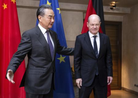 ドイツのショルツ首相（右）と写真撮影に臨む中国の王毅外相＝２月、ドイツ南部ミュンヘン（ＡＰ＝共同）