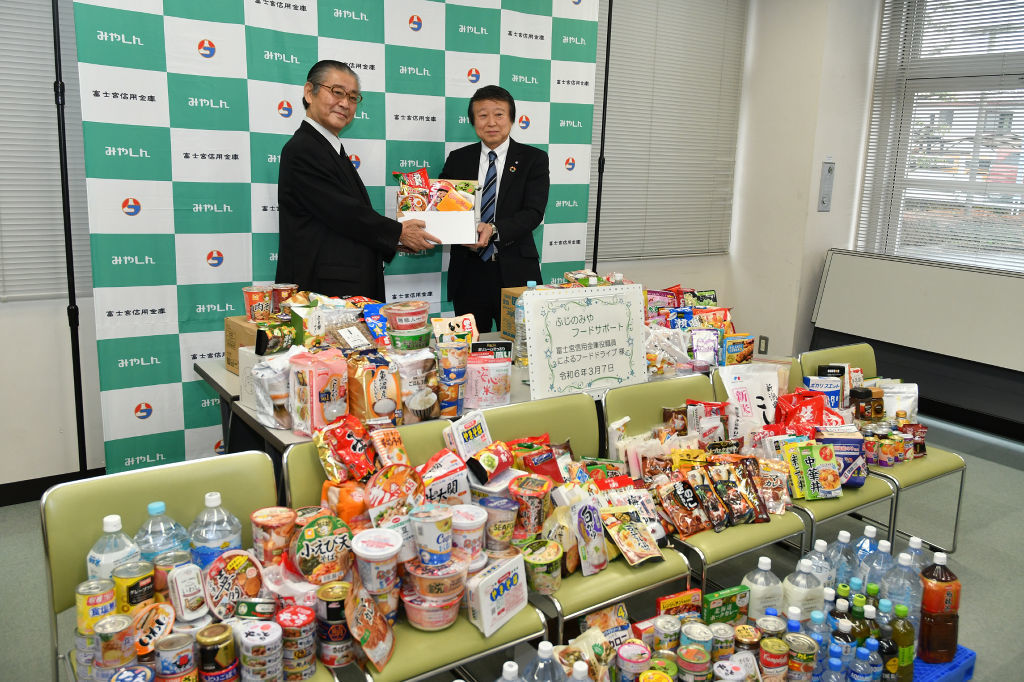 食料品を届けた小池理事長（右）＝富士宮市の市総合福祉会館