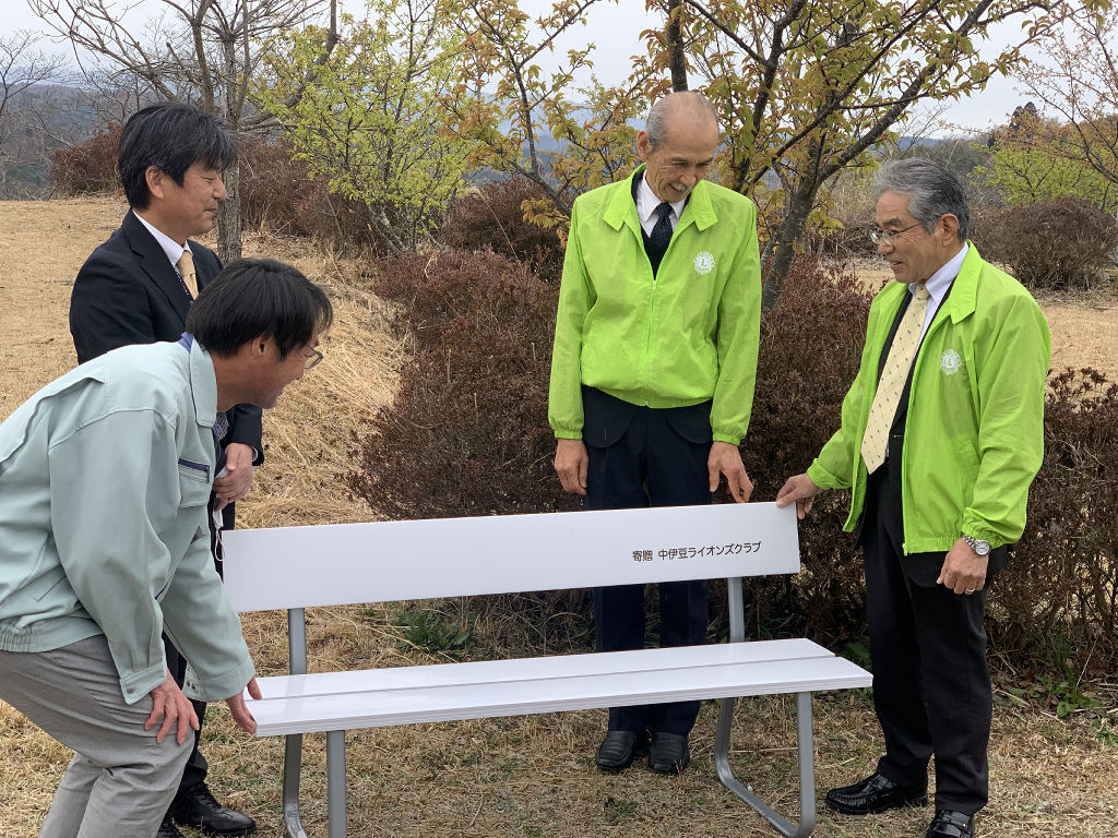 ベンチを寄贈した中伊豆ライオンズクラブのメンバー（右）＝伊豆市の六仙の里公園