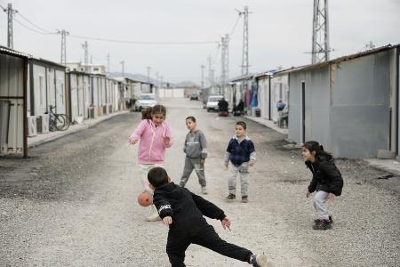 トルコ南部ヌルダーのコンテナ式の仮設住宅が並ぶ場所で遊ぶ子どもたち＝２月３日（共同）