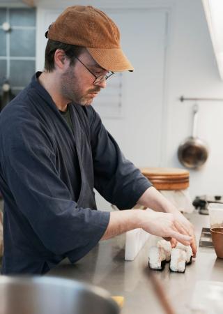 「ギリギリ」の店内でおにぎりを作るサミュエル・トリフォさん＝２月、パリ（共同）