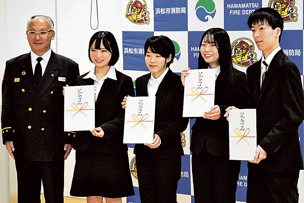 記念品を受け取った藤木さん（左から２人目）ら＝浜松市中央区の浜松未来総合専門学校