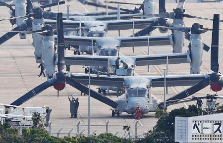 米海兵隊のＭＶ２２オスプレイが駐機する米軍普天間飛行場。飛行再開を前に準備する隊員の姿が見られた＝１４日午前、沖縄県宜野湾市
