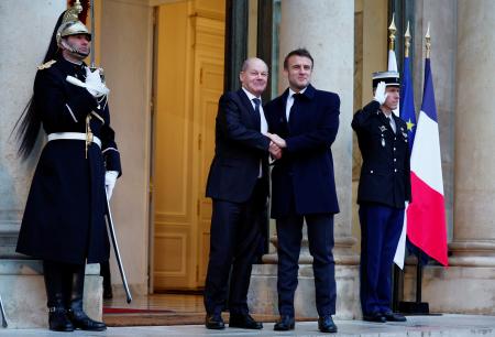ウクライナ支援会合出席のためフランス大統領府に到着したドイツのショルツ首相（中央左）と、迎えたマクロン大統領＝２月、パリ（ロイター＝共同）