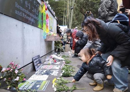 朝鮮人労働者の追悼碑に献花する人たち＝１月２８日午後