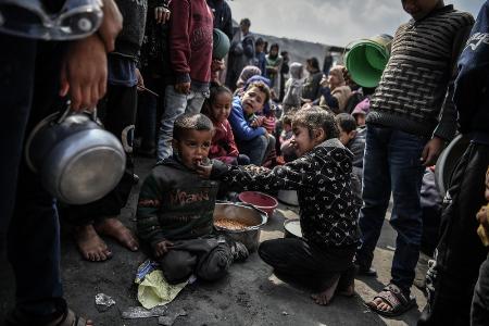 パレスチナ自治区ガザ南部ラファで、食料の配給を待つ子どもら＝２月（ゲッティ＝共同）