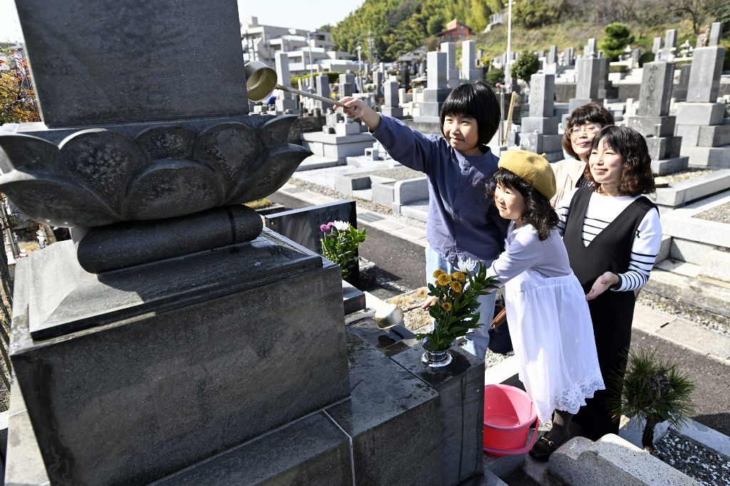 春の彼岸を迎え、墓を清める家族連れ＝１７日午前、静岡市葵区の愛宕霊園