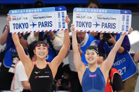 競泳五輪代表選考会の女子１００メートルバタフライでパリ五輪代表に決まり、ボードを掲げる優勝した平井瑞希（右）と２位の池江璃花子＝１８日、東京アクアティクスセンター