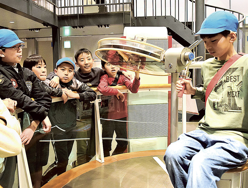 ハンドルを上下に動かし、いすの回転の変化を楽しむ児童（右）＝静岡市駿河区の静岡科学館る・く・る
