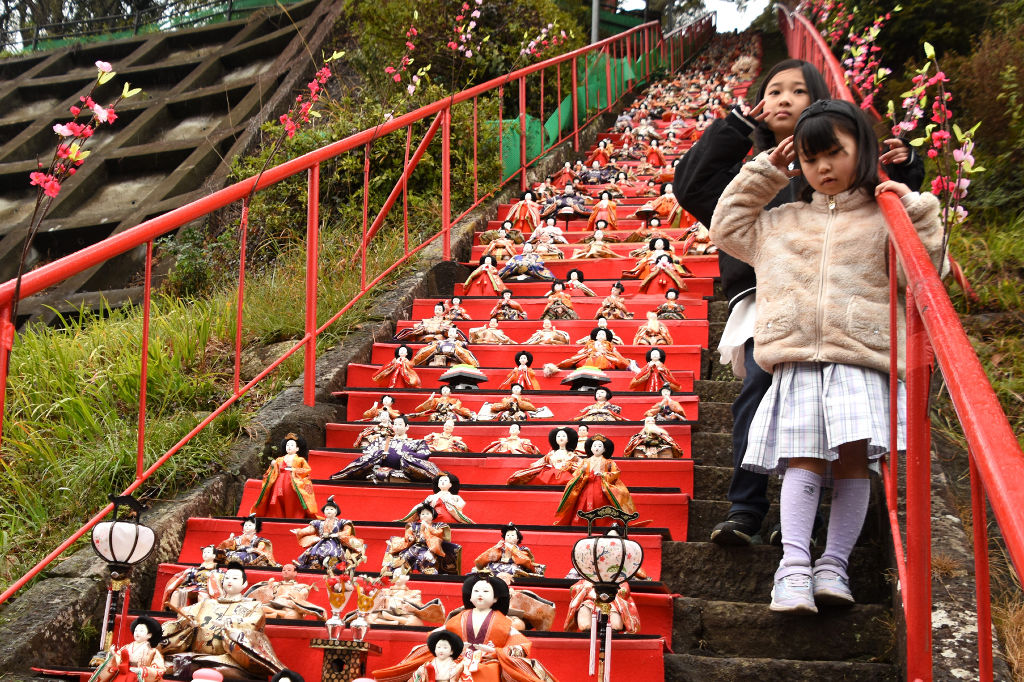 日本一をうたう１１８段のひな飾りと記念撮影する子どもたち＝下田市蓮台寺の天神神社
