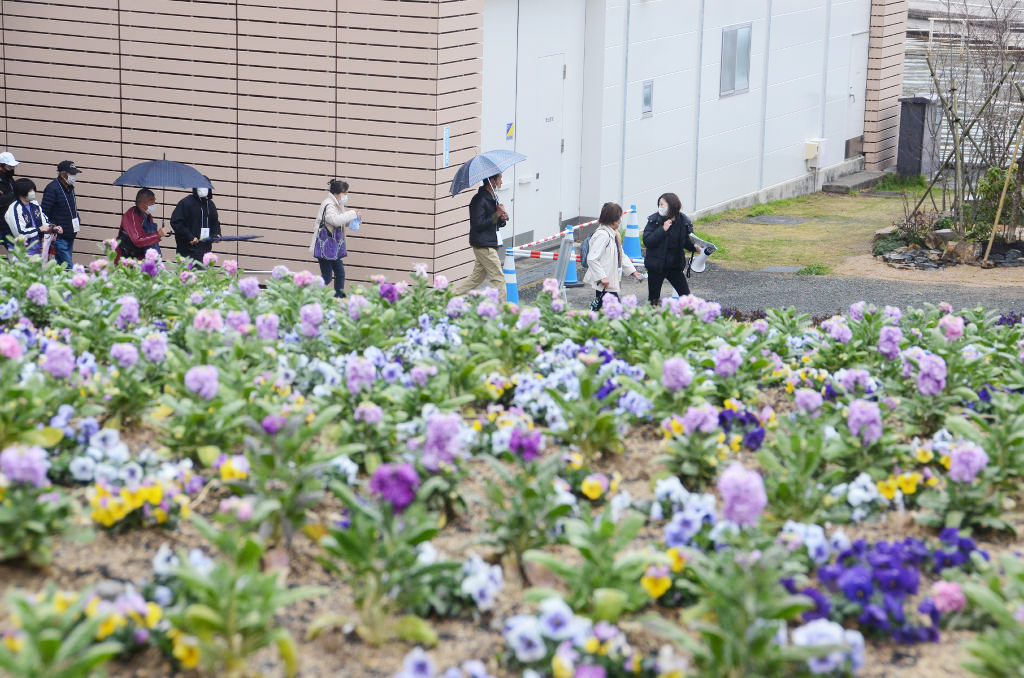 研修の担当者（右）の案内で施設などを確認するボランティア活動の参加者＝浜松市中央区の浜名湖ガーデンパーク
