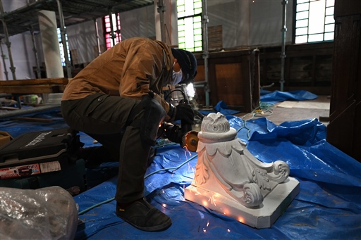解体作業が進む聖堂で、取り外されたマリア像の台座についている釘を切り取る作業員＝２月下旬