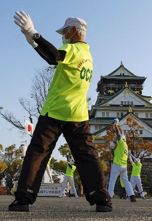 大阪城前の広場に集まり、健康のためラジオ体操をする高齢者たち＝２０２０年４月