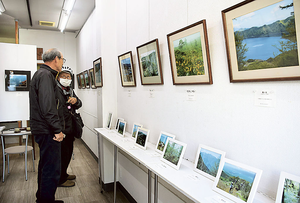 塩谷代表が初心者向きと薦める山を紹介する写真展＝焼津市本町の藍画廊