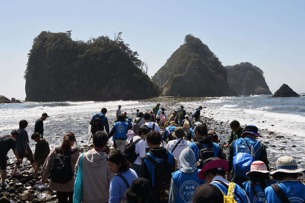 トンボロ現象によって出現した〝海の道〟を渡る観光客ら＝西伊豆町仁科の瀬浜海岸
