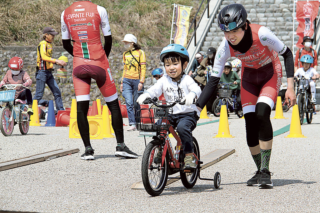 鈴木選手と自転車を練習する参加者＝島田市の蓬莱橋イベント広場