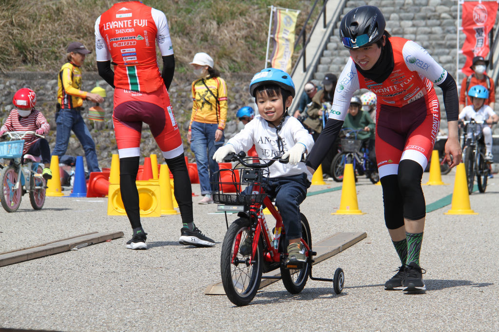 鈴木選手と自転車を練習する参加者＝島田市の蓬莱橋イベント広場