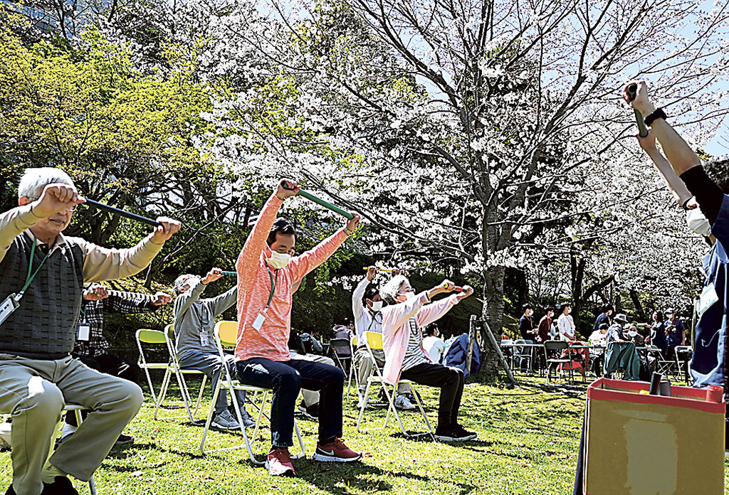 「棒体操」で体を動かす参加者＝静岡市葵区の駿府城公園