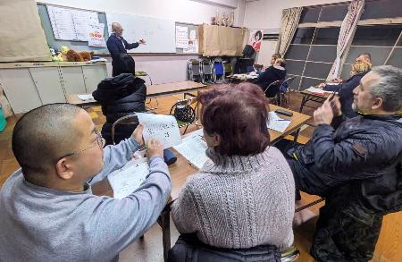 小野一馬さん（手前左）が大分県別府市の集会場で開いているウクライナ避難民の日本語教室。奥は通訳者の山口英文さん＝２月