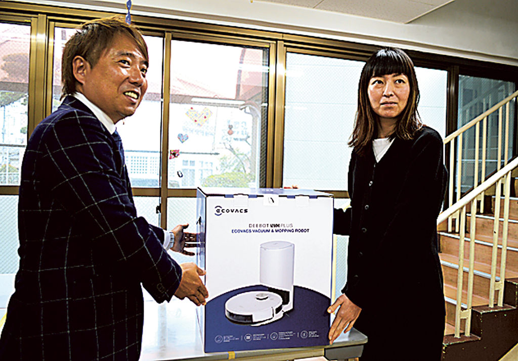 ロボット掃除機を贈る石川会長（左）＝長泉町の児童養護施設「聖心養護園」