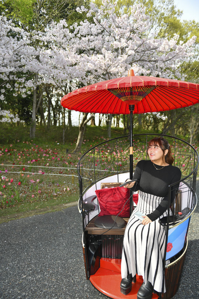 傘をテーマにしたモビリティー「アンブレラ」を体験するなな茶さん＝浜松市中央区の浜名湖ガーデンパーク