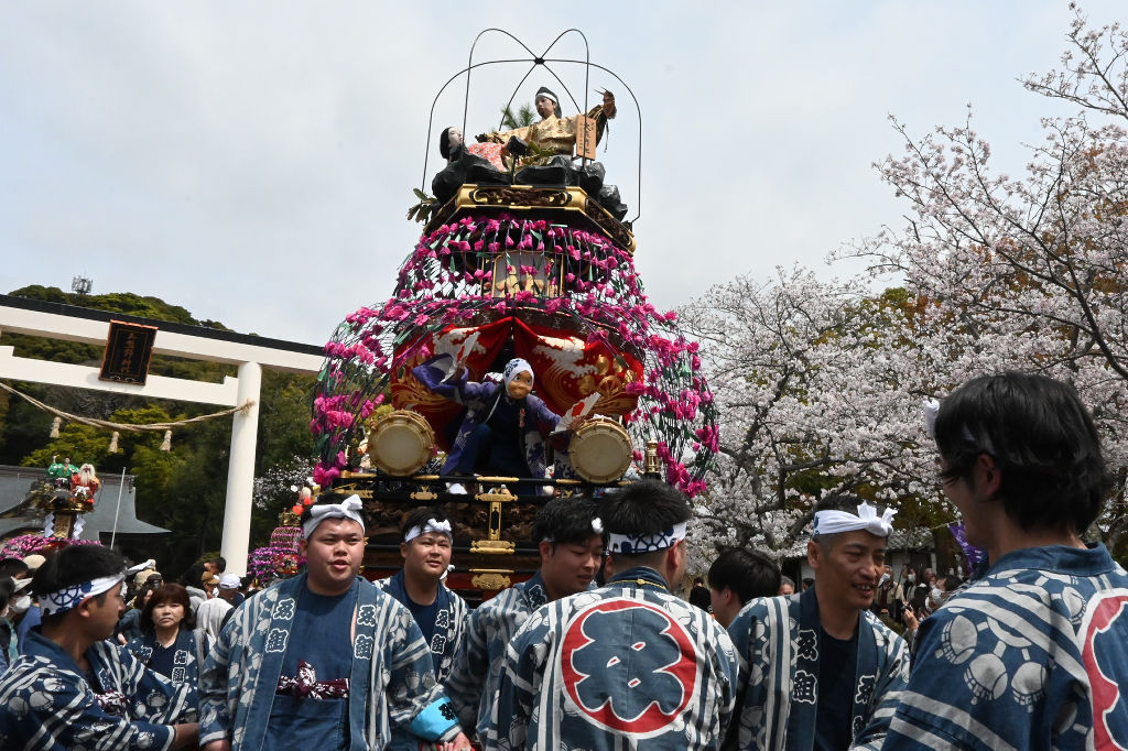 豪快なかけ声とともに、華やかな祢里を引く青年ら＝掛川市西大渕の三熊野神社