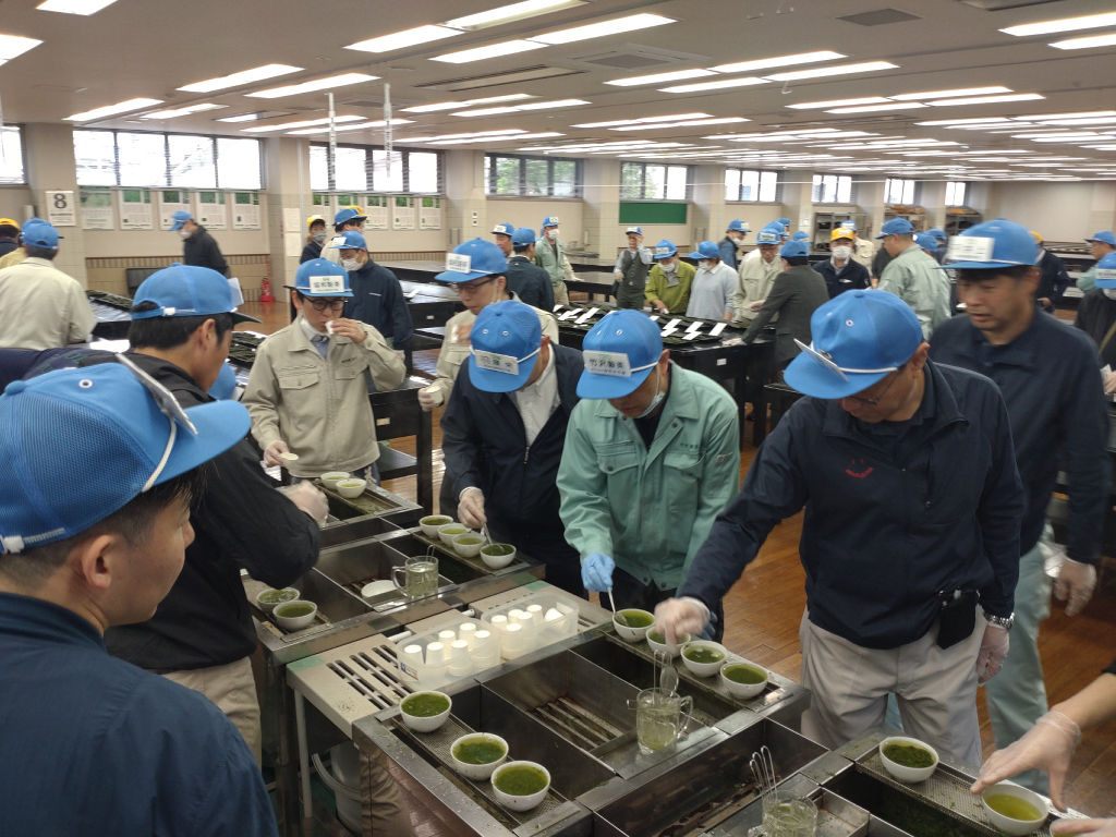 初上場した鹿児島県本土物一茶を鑑定する茶商ら＝８日午前、静岡市葵区の静岡茶市場