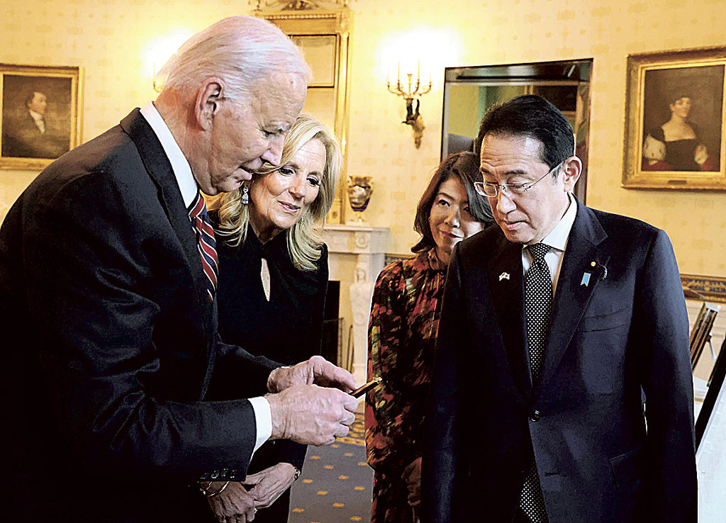 米バイデン大統領（左）に贈呈品を渡す岸田首相＝９日、米ワシントンのホワイトハウス（内閣広報室提供、共同）