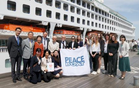 ピースボートへの乗船前、記念撮影するウクライナ出身の若者や広島、長崎の被爆者ら＝１３日午前、横浜市