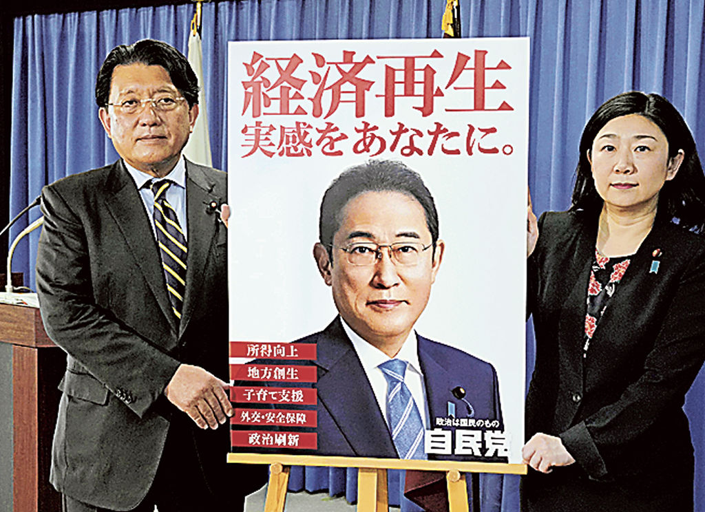 自民党の新しいポスターを発表する平井卓也広報本部長（左）ら＝１５日午後、東京・永田町の党本部