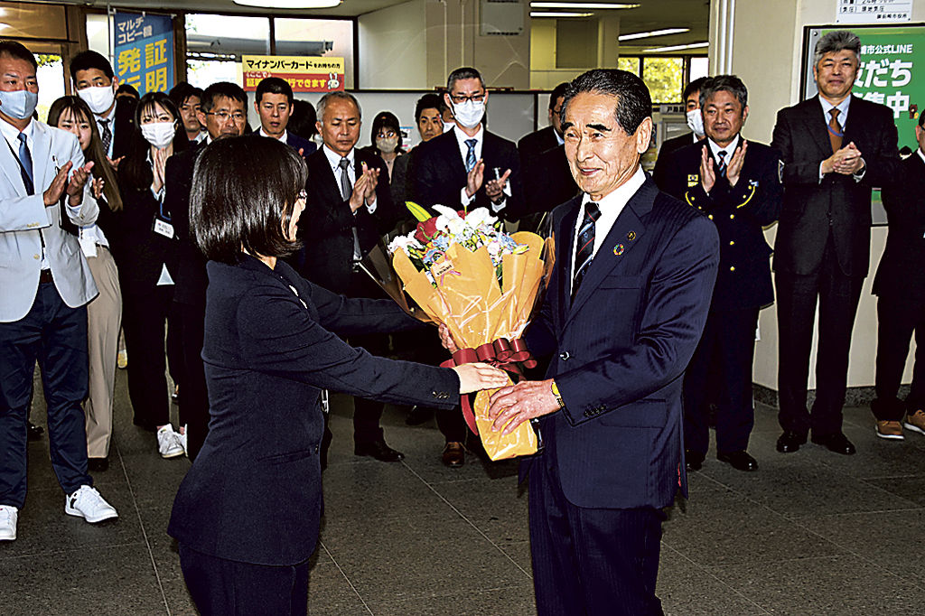 職員の拍手を受けながら花束を受け取る柳沢市長（右）＝御前崎市役所