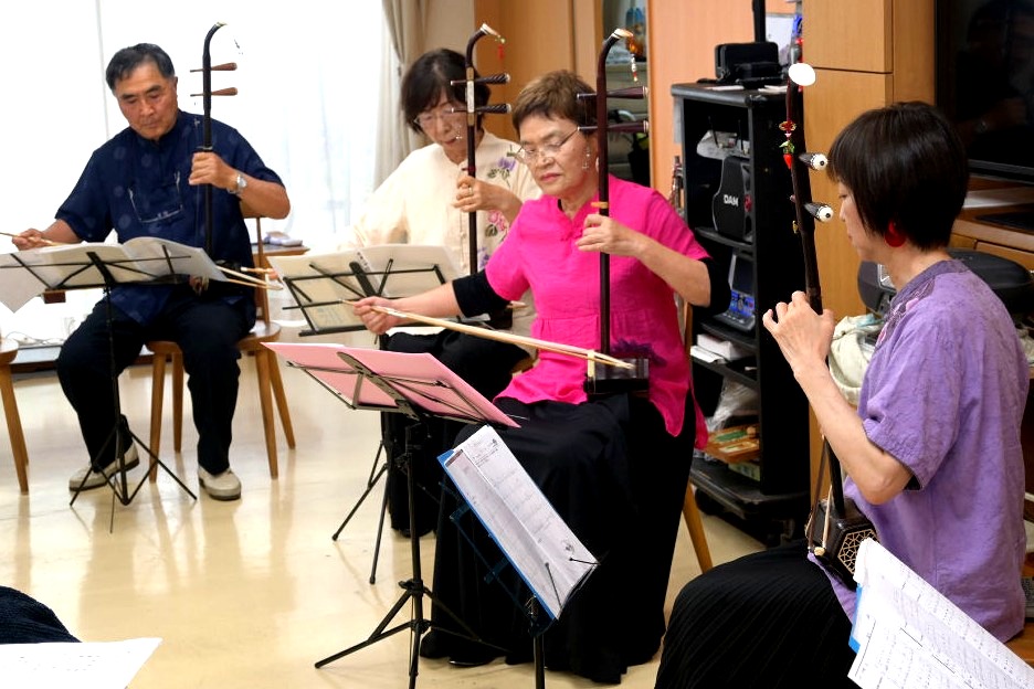 利用者の前で二胡を演奏する同好会メンバー＝静岡市駿河区の自立支援型デイサービス「てるてるぼうず」