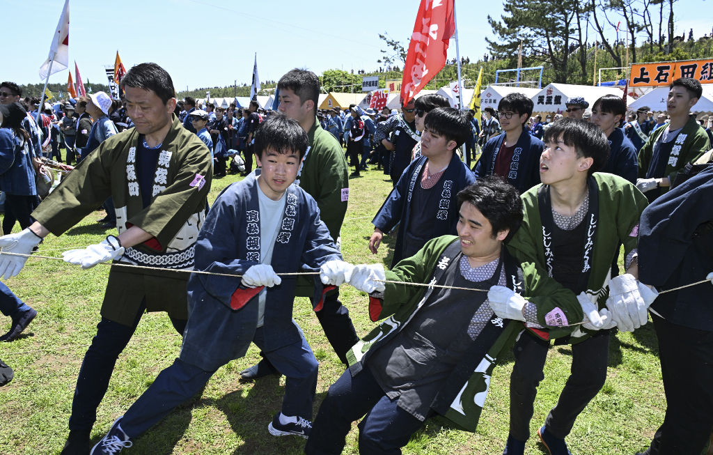 糸を引く作業に汗を流す学生ら＝浜松市中央区の凧揚げ会場