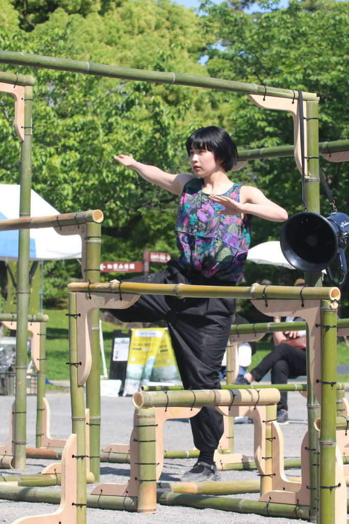 ダンサーや建築家からなるプロジェクト「浅川奏瑛×演劇空間ロッカクナット」。竹製の構築物に沿うように、浅川さんが滑らかなダンスを繰り広げた