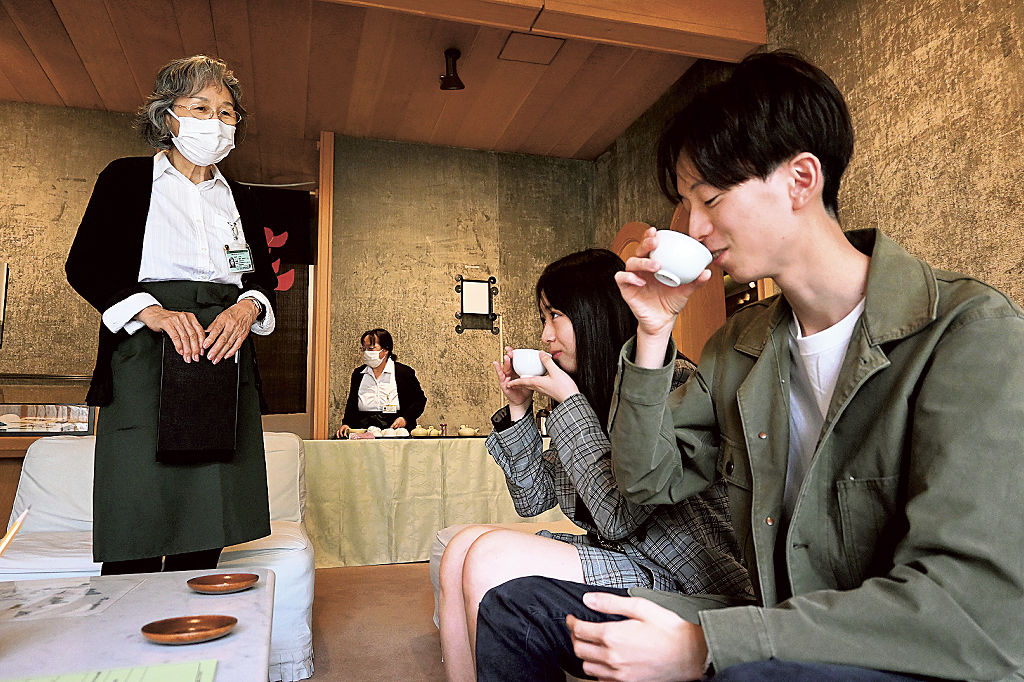 日本茶インストラクター（左）から本山茶を振る舞われる来館者＝静岡市駿河区の市立芹沢ケイ介美術館