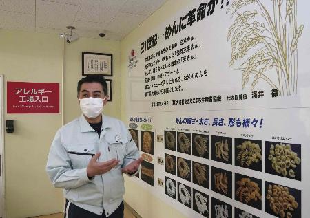 大潟村あきたこまち生産者協会のアレルギー工場入り口付近では、米を使った各種の麺が紹介されている＝２０２４年２月、秋田県大潟村