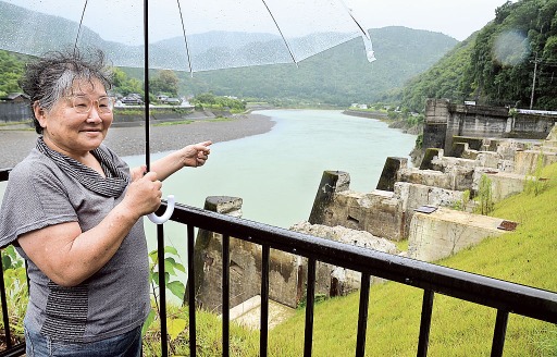 荒瀬ダムの取水口跡を指さす、つる詳子さん。撤去により、球磨川は本来の流れを取り戻しつつある＝７月２０日、熊本県八代市坂本町