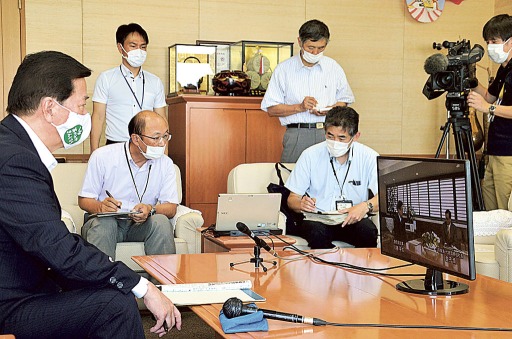 トップ会談の映像に見入る松井三郎掛川市長（左）と市担当者ら＝２６日午後、掛川市役所