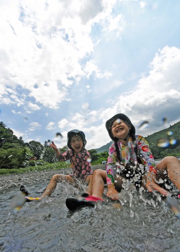 雲間からのぞく青空の下、水遊びに歓声を上げる子どもたち＝１日午後０時半、静岡市葵区桂山の中河内川