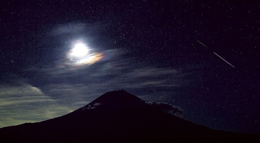 昇り始めた月が富士山上空を彩る中、夜空を横切る「ペルセウス座流星群」の流星＝１４日午前１時４０分、富士宮市（３秒露光）