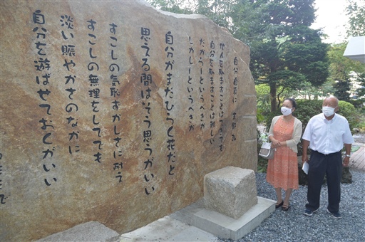 「自分自身に」が刻まれた石碑を見つめる梅原さん（左）と庄司会長＝富士市大淵のエスプラット・フジスパーク