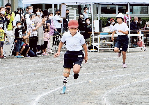 競技用義足で徒競走を走る高木翔梧君（手前）＝２６日午前、下田小