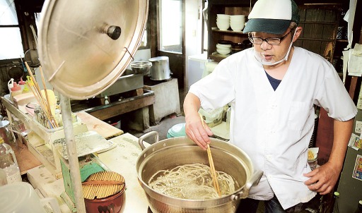祖父の代から約１００年使われている調理場に立つ高林さん＝浜松市浜北区の「いろはや」